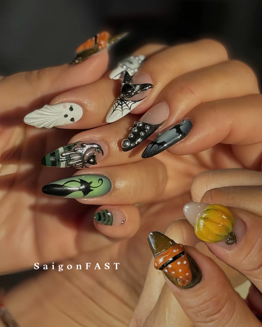 Halloween nail art with ghosts, a spiderweb, bats and green, black and orange details